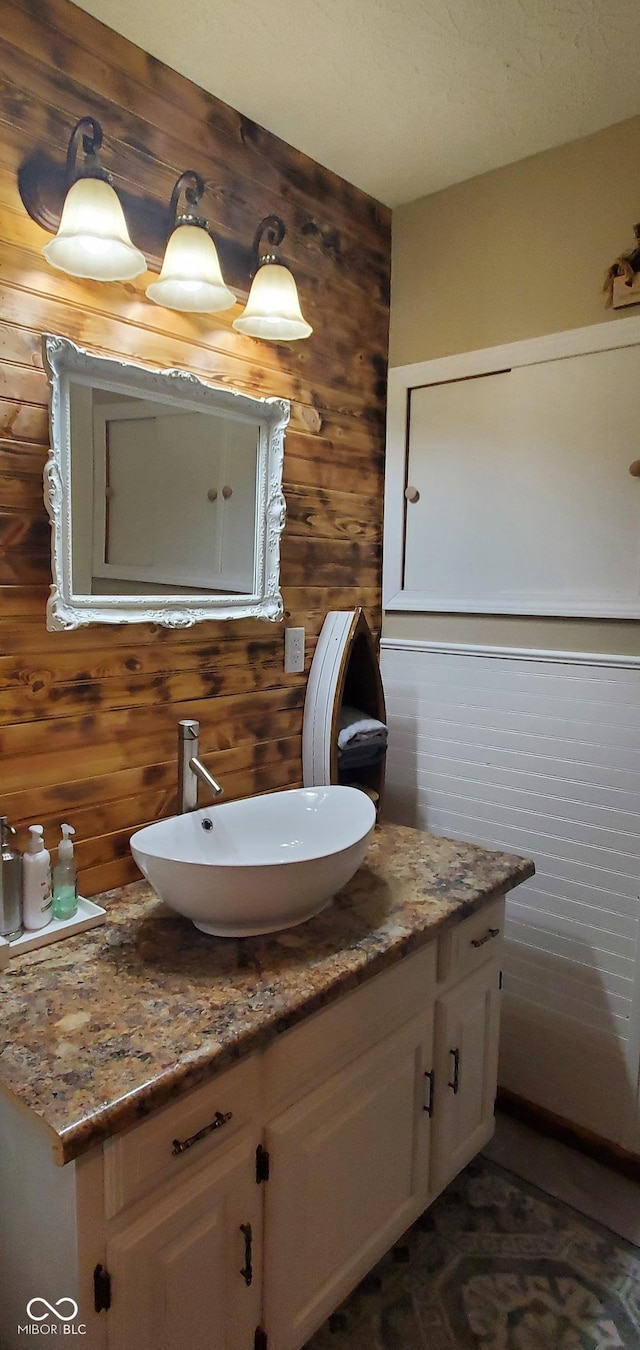 bathroom featuring wooden walls and vanity