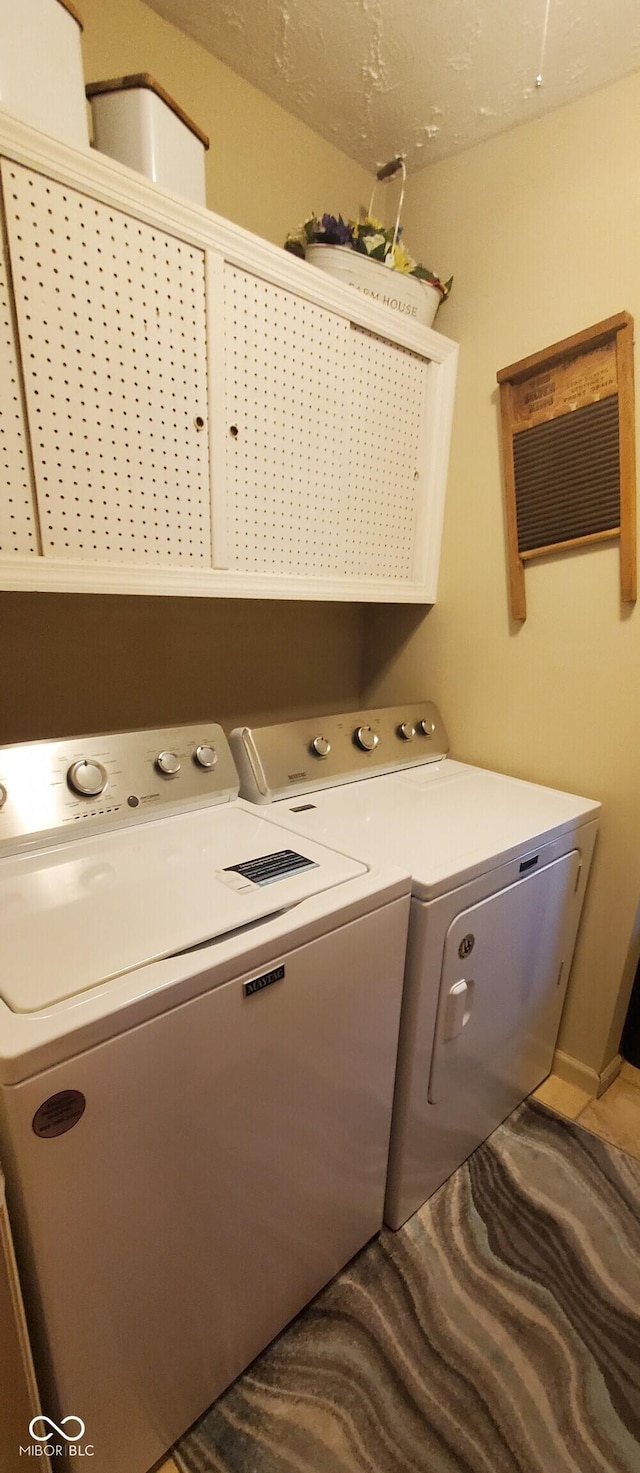 clothes washing area with cabinet space and washer and dryer