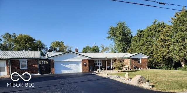 ranch-style home with brick siding, driveway, a front lawn, and a garage