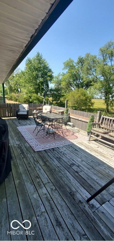wooden terrace with fence and outdoor dining space