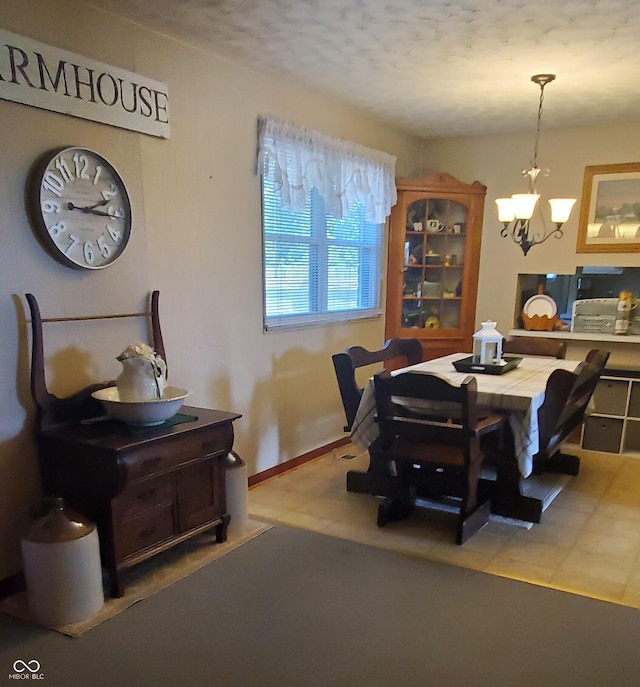 dining space featuring baseboards and a chandelier