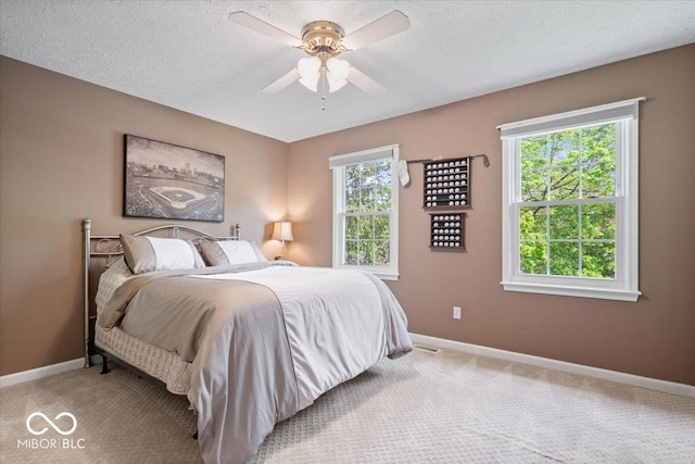 bedroom featuring carpet flooring, a textured ceiling, and baseboards