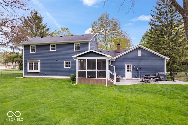 back of property featuring a sunroom, a yard, a chimney, and a patio
