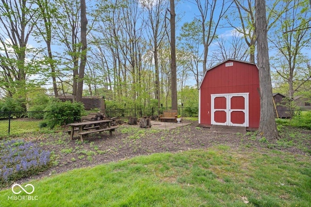 view of yard with a storage unit, fence, and an outbuilding
