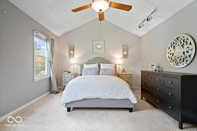 bedroom with lofted ceiling, light carpet, baseboards, ceiling fan, and rail lighting