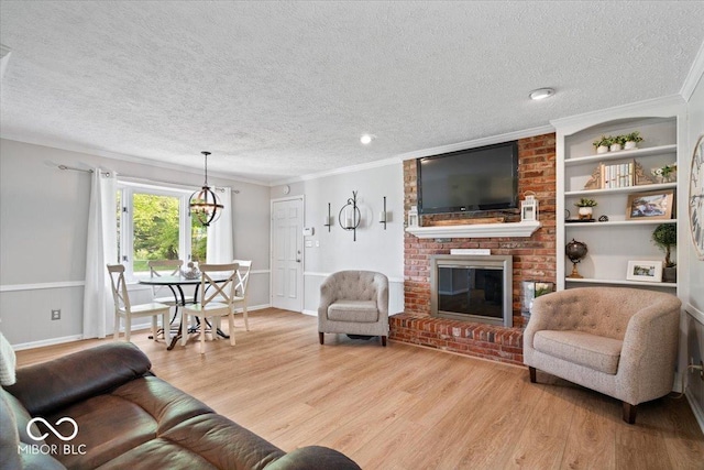 living room featuring crown molding, light wood-style flooring, a textured ceiling, and a brick fireplace