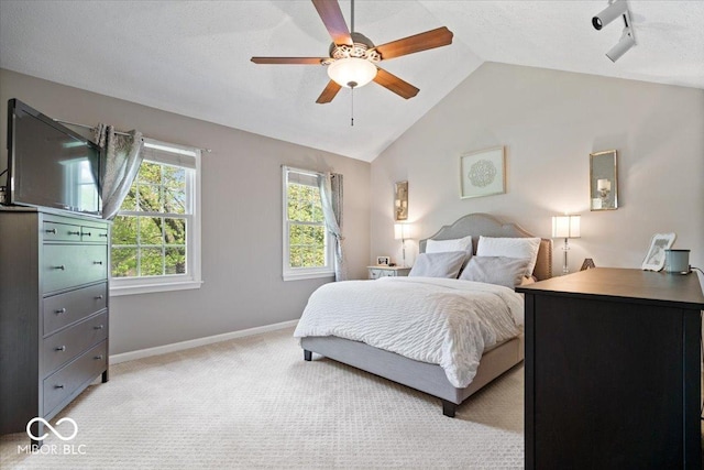 bedroom with ceiling fan, light colored carpet, vaulted ceiling, rail lighting, and baseboards