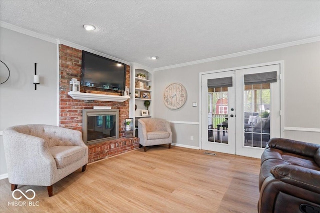 living area featuring crown molding, a textured ceiling, french doors, and wood finished floors
