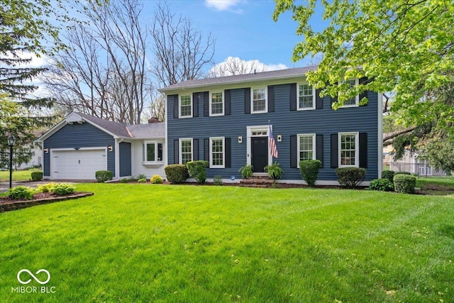 colonial house featuring a front lawn and a garage