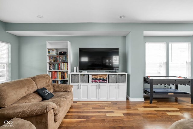 living room with recessed lighting, baseboards, and light wood finished floors