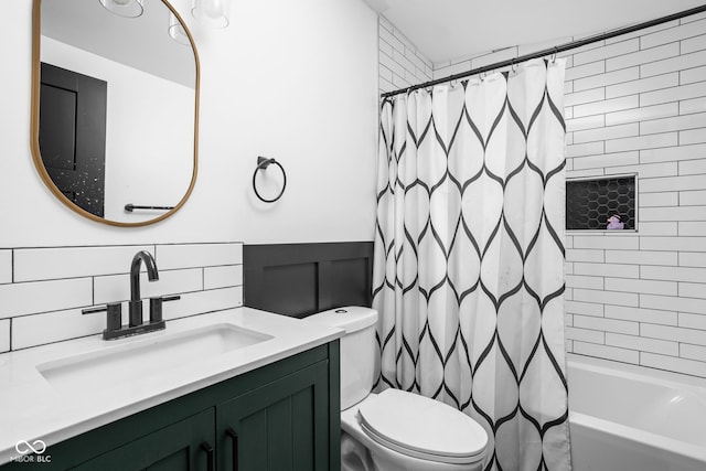 full bath with vanity, a wainscoted wall, shower / bath combo, and toilet