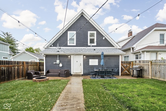 back of house with a lawn, a fenced backyard, an outdoor living space with a fire pit, and a patio