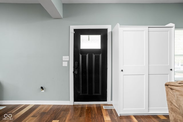entrance foyer featuring baseboards, wood finished floors, and visible vents