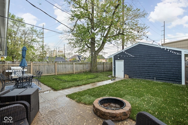 view of yard featuring a fire pit, a fenced backyard, and a patio area