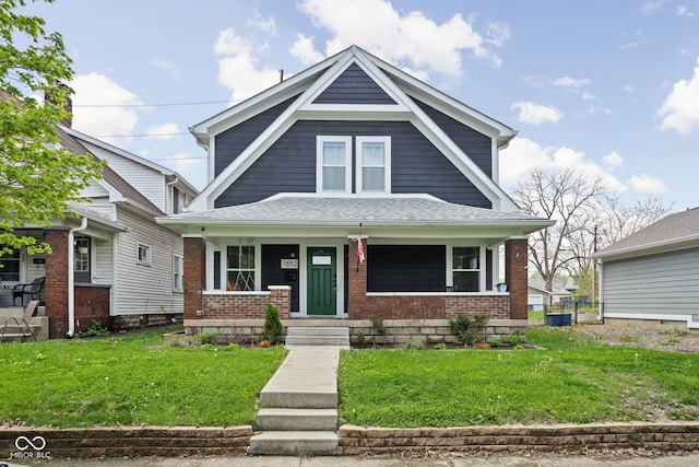 view of front of home with brick siding, a front yard, and a porch