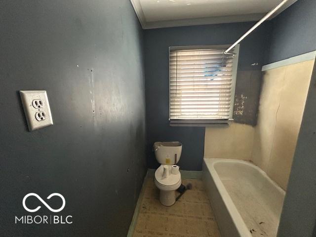 bathroom featuring tile patterned flooring, toilet, a tub, baseboards, and a shower