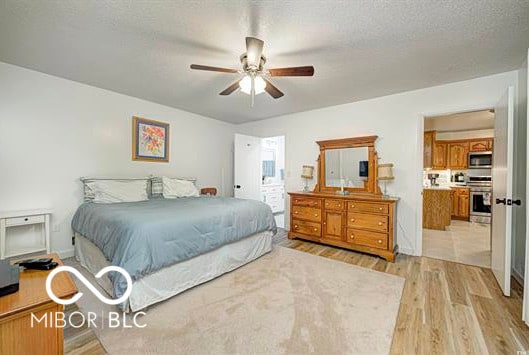 1391 S River Rd, Covington, IN 47932 - bedroom with light wood-style floors, a ceiling fan, and a textured ceiling