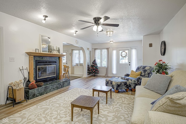 1391 S River Rd, Covington, IN 47932 - living area featuring a textured ceiling, ceiling fan, a fireplace, and wood finished floors