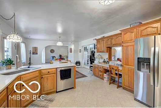 1391 S River Rd, Covington, IN 47932 - kitchen featuring decorative light fixtures, appliances with stainless steel finishes, arched walkways, a sink, and light countertops