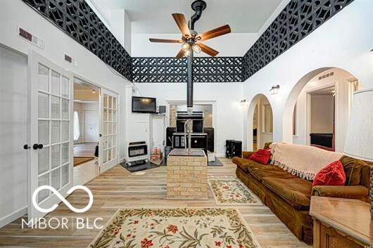 1391 S River Rd, Covington, IN 47932 - living room featuring french doors, a towering ceiling, wood finished floors, and ceiling fan