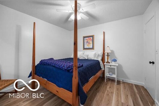 1391 S River Rd, Covington, IN 47932 - bedroom featuring baseboards, ceiling fan, and wood finished floors