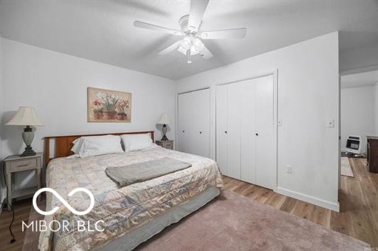 1391 S River Rd, Covington, IN 47932 - bedroom with baseboards, ceiling fan, wood finished floors, and two closets