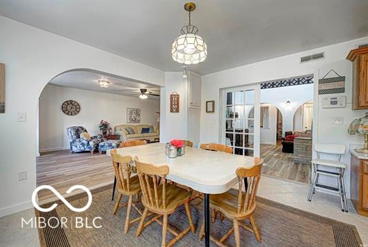 1391 S River Rd, Covington, IN 47932 - dining area with visible vents, baseboards, light wood-style floors, ceiling fan, and arched walkways