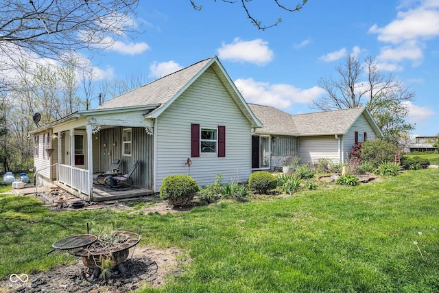 5780 S County Road 625 W, Reelsville, IN 46171 - back of house featuring a shingled roof, a yard, and a fire pit