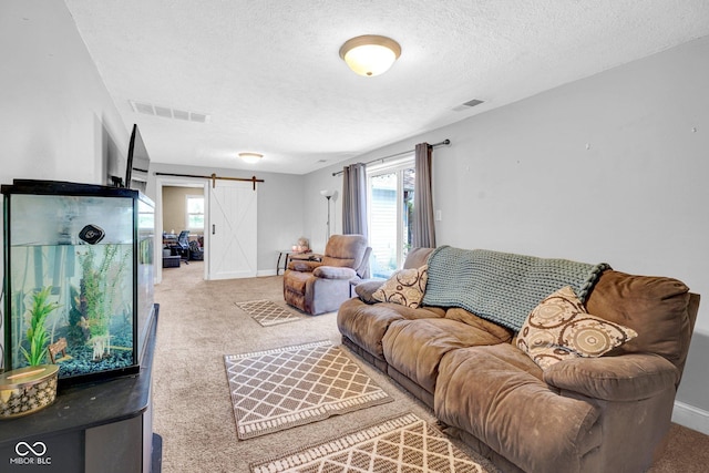 5780 S County Road 625 W, Reelsville, IN 46171 - carpeted living room with visible vents, a barn door, a textured ceiling, and a wealth of natural light