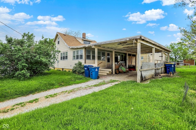 509 S Main St, Greencastle, IN 46135 - rear view of property featuring a chimney, driveway, an attached carport, and a yard
