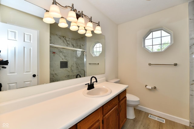 bathroom with toilet, a marble finish shower, baseboards, wood finished floors, and visible vents