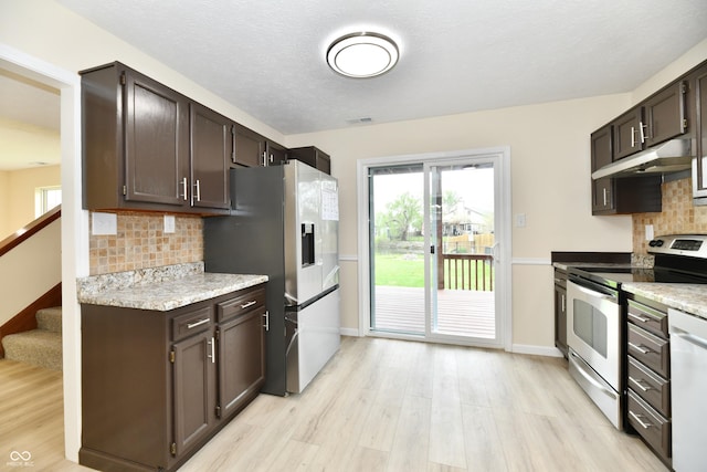 kitchen featuring backsplash, visible vents, appliances with stainless steel finishes, light wood-type flooring, and under cabinet range hood