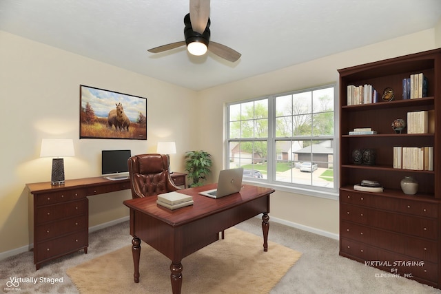 office space with baseboards, light carpet, and a ceiling fan