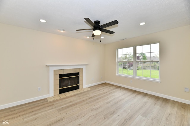 unfurnished living room featuring ceiling fan, recessed lighting, baseboards, wood finished floors, and a tile fireplace
