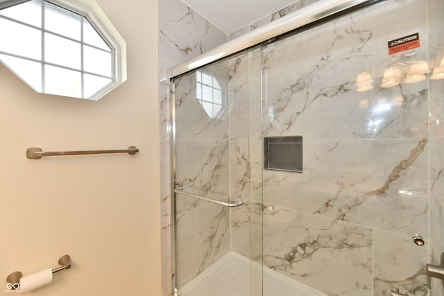 bathroom with a marble finish shower