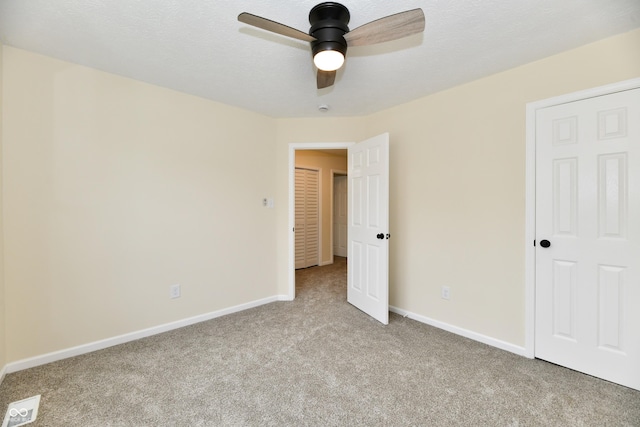 unfurnished bedroom with carpet floors, baseboards, ceiling fan, and visible vents