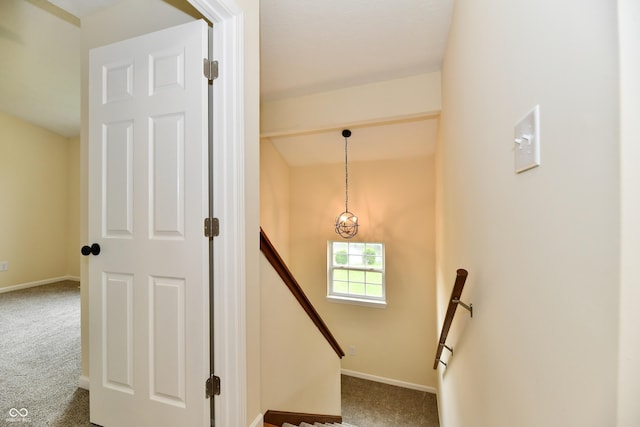 staircase featuring carpet floors and baseboards