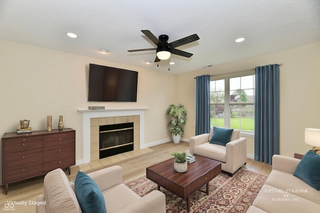 living area with recessed lighting, light wood-style flooring, ceiling fan, and a tile fireplace