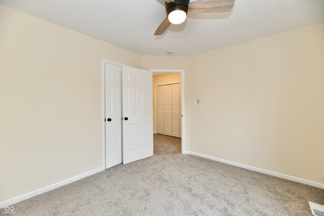 unfurnished bedroom with carpet floors, a ceiling fan, baseboards, and a closet