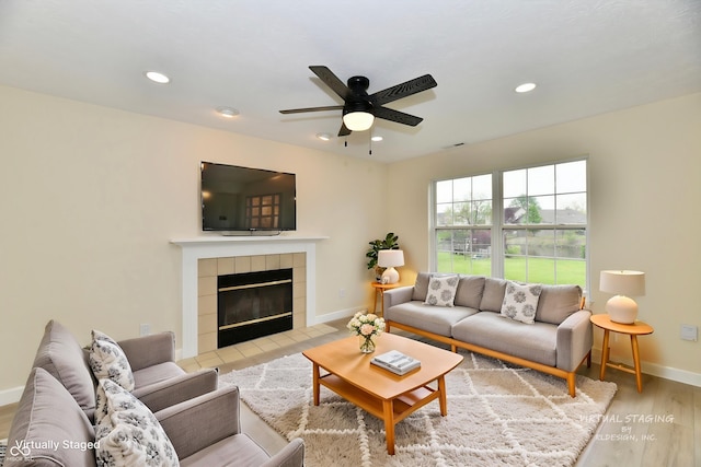 living area with a ceiling fan, baseboards, recessed lighting, wood finished floors, and a tile fireplace