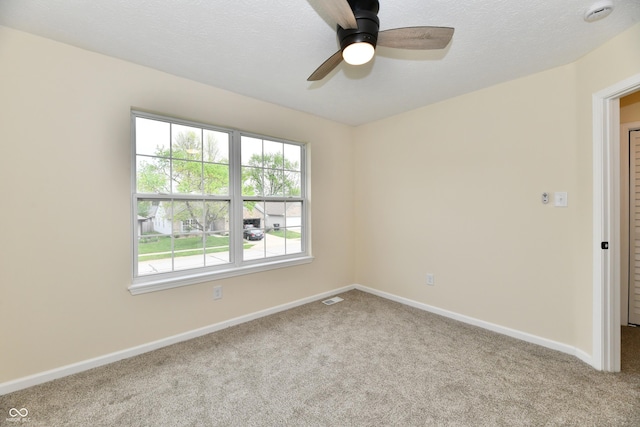 unfurnished room with a ceiling fan, baseboards, visible vents, and carpet