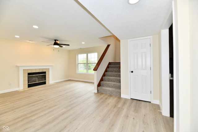 unfurnished living room featuring light wood-style floors, a ceiling fan, baseboards, recessed lighting, and stairway
