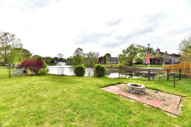 view of yard with a patio, a water view, a fire pit, and fence