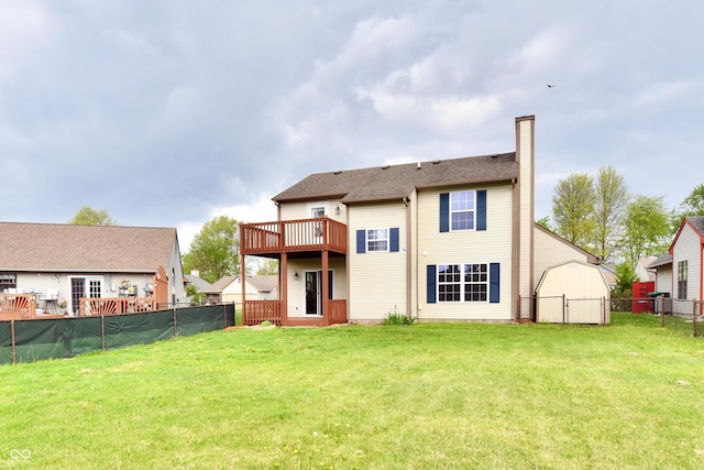 back of house featuring a lawn, a fenced backyard, a chimney, and a deck