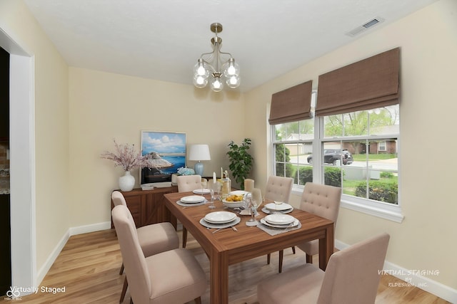 dining space with an inviting chandelier, baseboards, light wood-style flooring, and visible vents