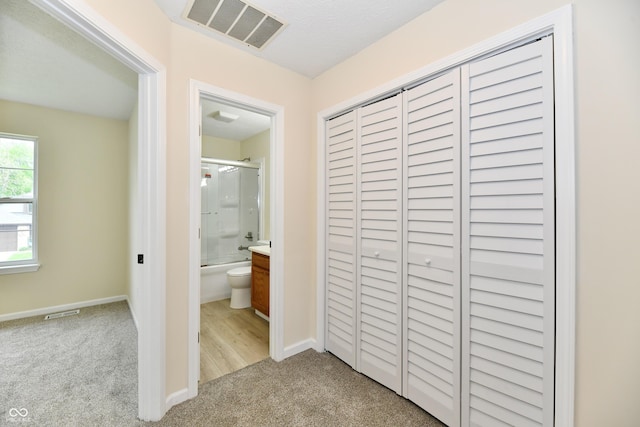 interior space featuring baseboards, visible vents, and light carpet
