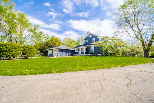 view of front facade with a garage, a front yard, and a chimney