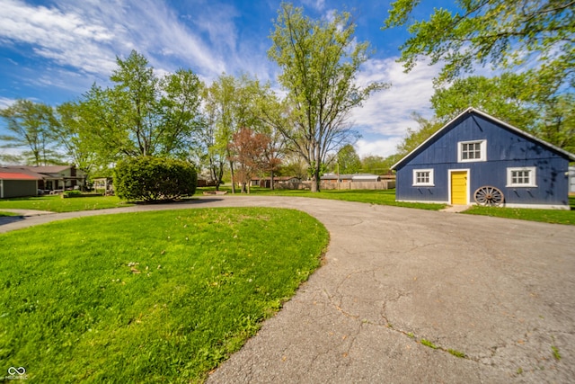 view of home's exterior with curved driveway and a lawn