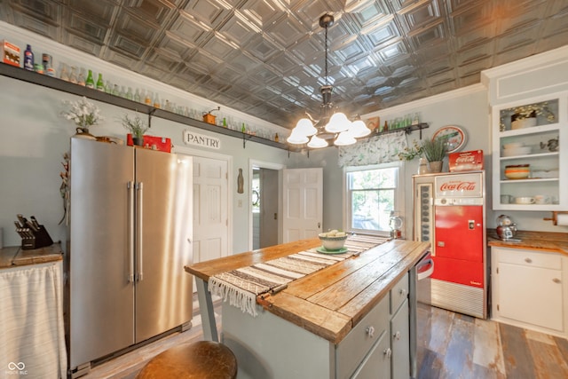 kitchen featuring an ornate ceiling, butcher block countertops, ornamental molding, and high quality fridge