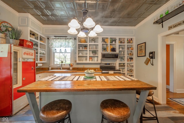 kitchen with open shelves, an inviting chandelier, an ornate ceiling, wooden counters, and stainless steel appliances